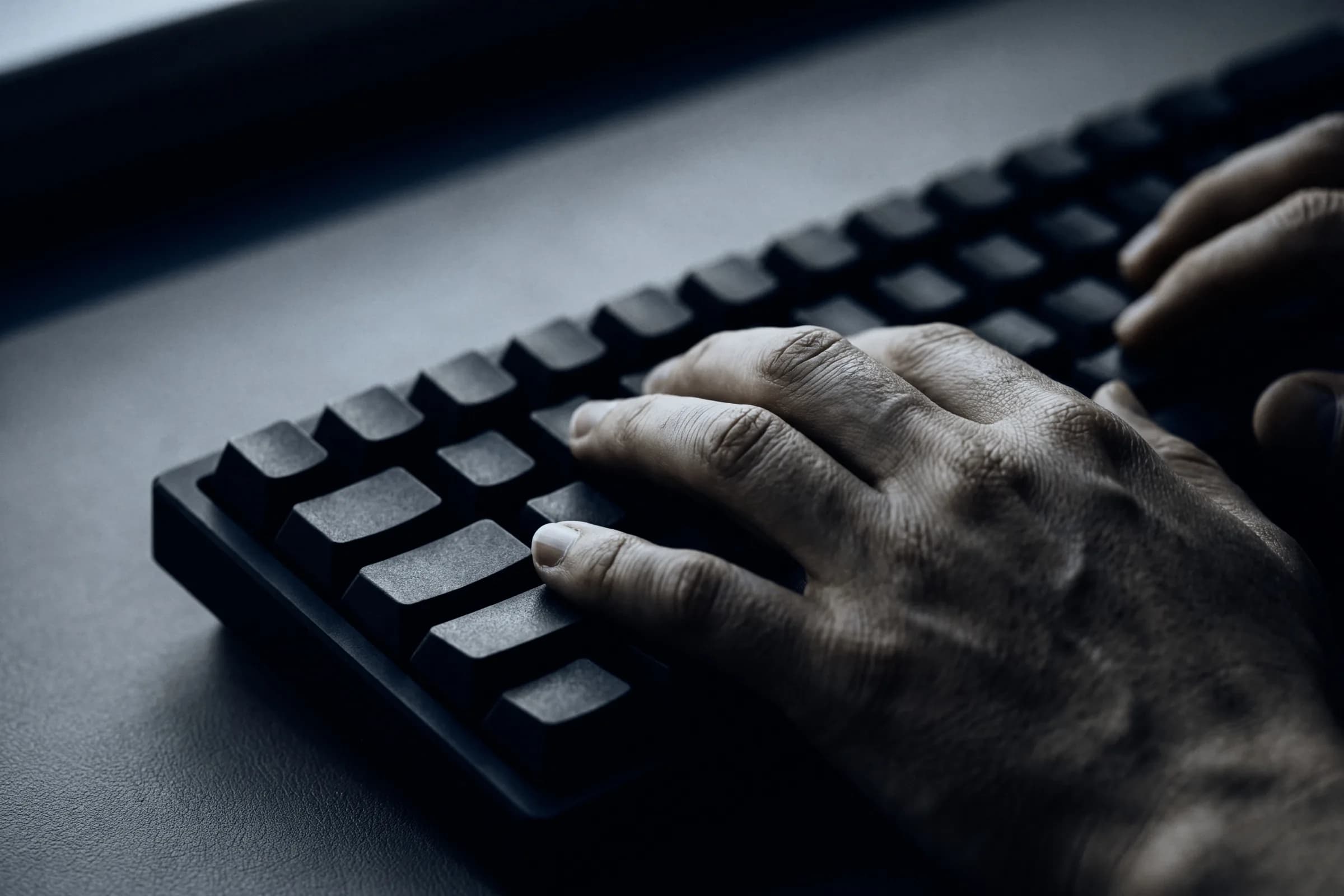 A hand on a dark keyboard