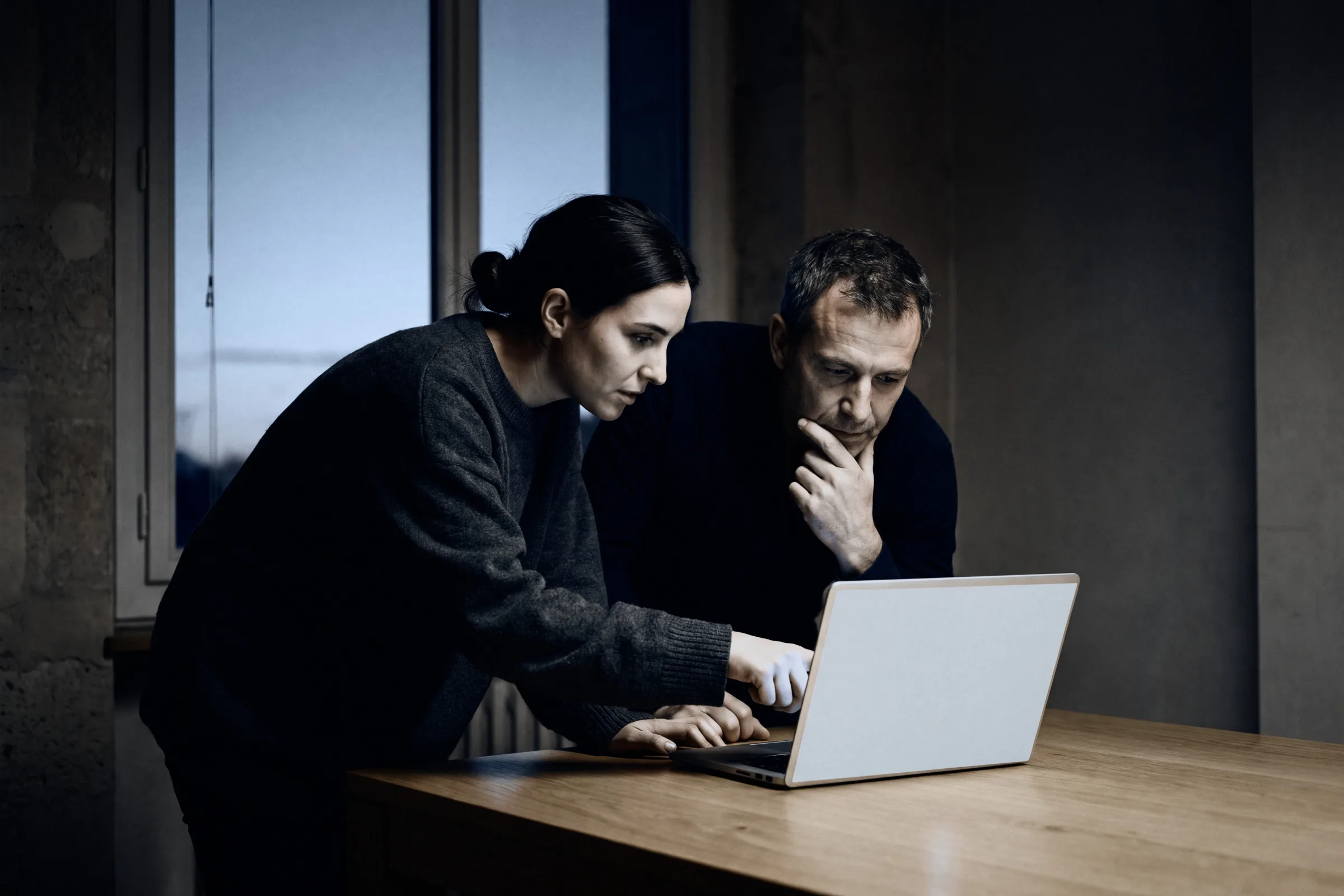 Two founders working through a problem at a laptop