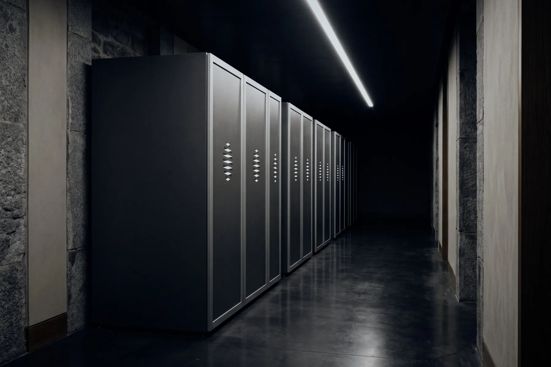 A row of server cabinets in a long, dim server room
